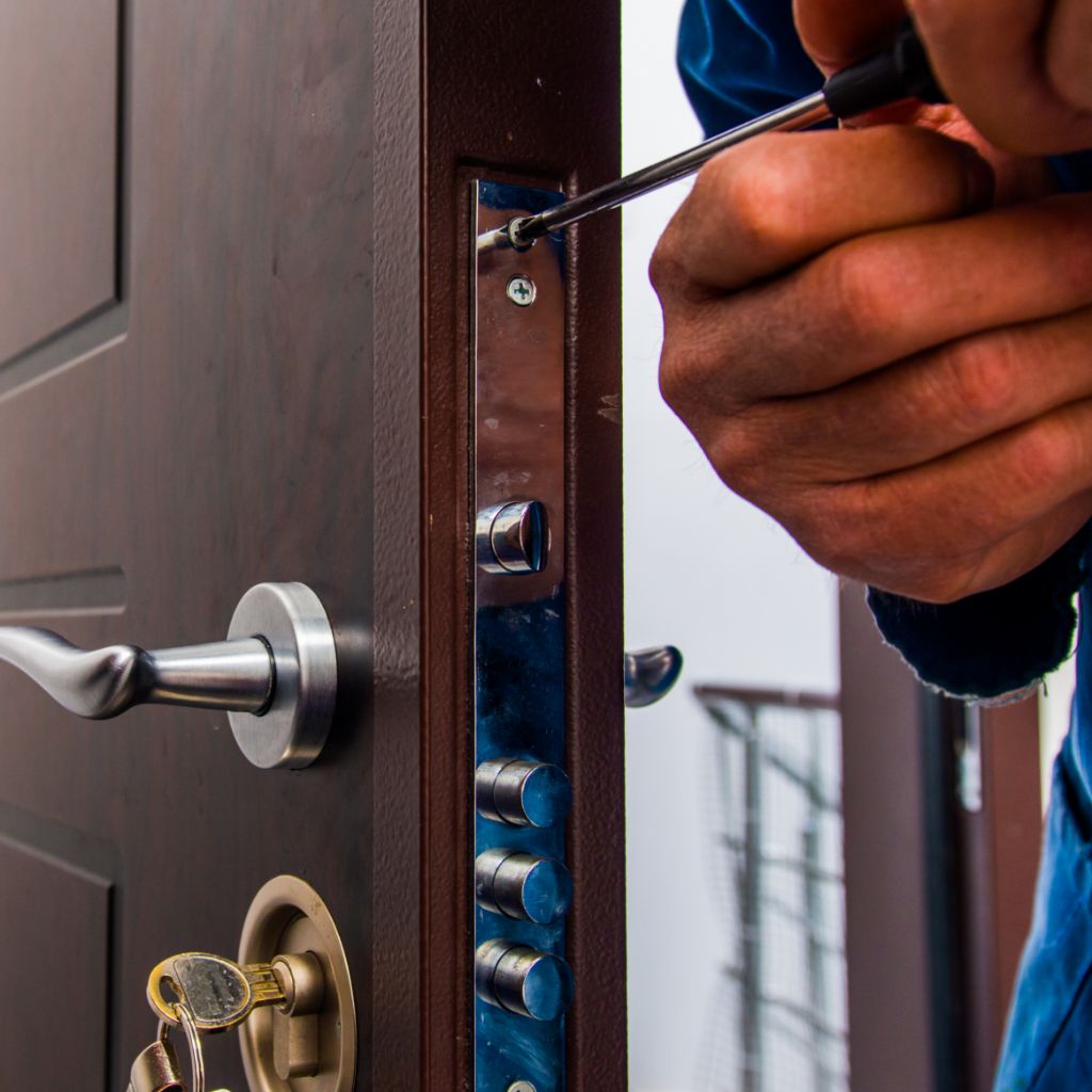 Tecnico al lavoro sulla sostituzione di una serratura su porta blindata